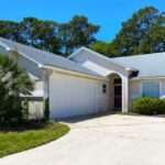 A beautiful stucco home for sale in Atlantic Beach, FL in the daytime.