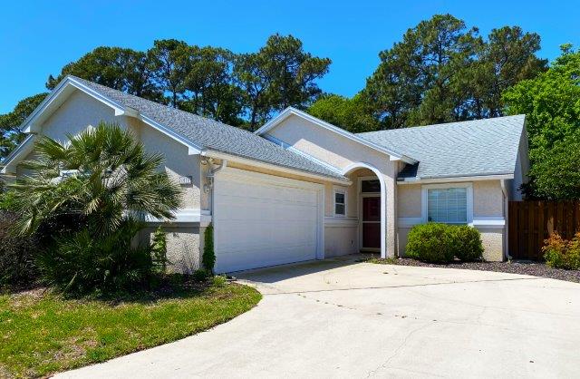 A beautiful stucco home for sale in Atlantic Beach, FL in the daytime.